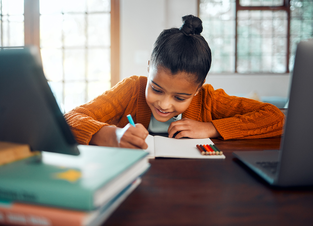 mission image Girl writing on a pad in front of a monitor